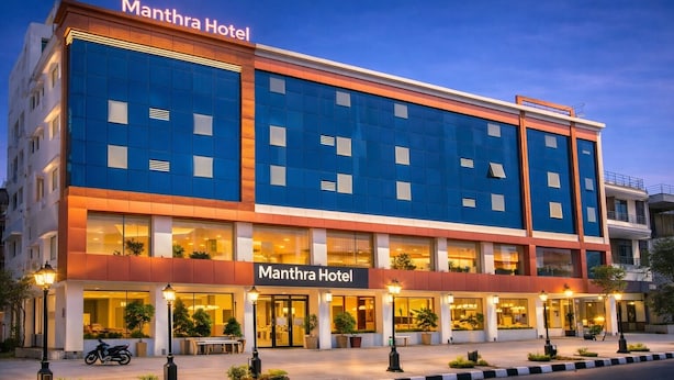 A modern hotel building with a prominent sign reading 'Manthra Hotel.' - Manthra Hotel Arakere Bannerghatta (Bengaluru)