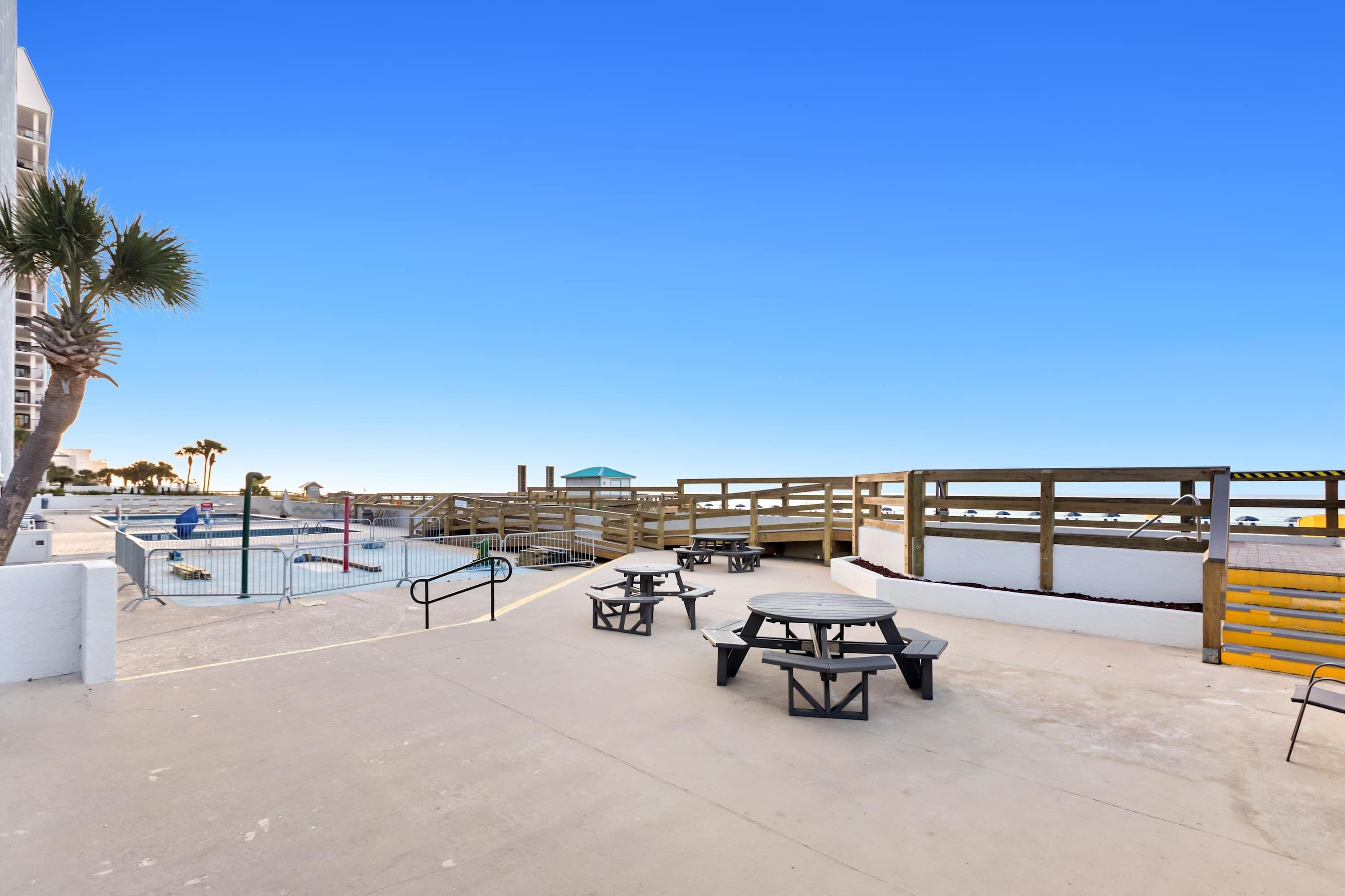A rooftop pool area with picnic tables and a wooden deck.