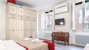 Ein Hotelzimmer mit Bett, Kleiderschrank, Schminktisch und Fernseher.