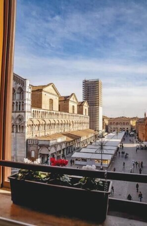 A view from a window overlooking a street with historic buildings and a modern skyscraper. - Exclusive suite with Cathedral view | Elegant design in the heart of Ferrara (Ferrara)