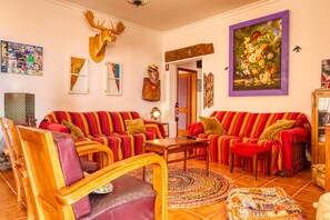 A living room with striped sofas, a wooden coffee table, and a patterned rug. - Casa Saudade, a Home in Madeira (Porto Santo)