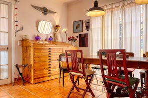 A dining area with wooden furniture, a chandelier, and wall decorations. - Casa Saudade, a Home in Madeira (Porto Santo)