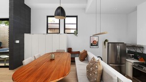 A modern kitchen with a dining area, a sofa, and a large window. - Alluring Sophistication Meets Mid-Century Chic (Austin)