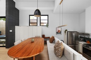 A modern kitchen with a dining area, a sofa, and a large window. - Alluring Sophistication Meets Mid-Century Chic (Austin)