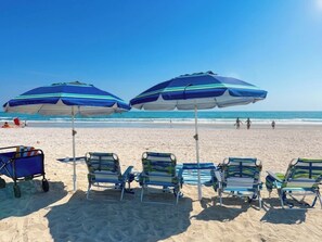 Ein Strand mit Sonnenschirmen und Liegestühlen.