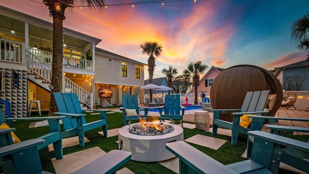 A backyard with a fire pit, outdoor seating, and a pool. - Walk 2 Beach |Theater, Games, Putt, Pool, Sleep 22 (North Myrtle Beach)