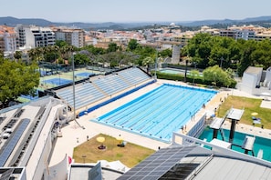 A large swimming pool with multiple lanes, surrounded by buildings and trees. - Algarve Townhouse in Loulé by MGM Stays (Loulé)