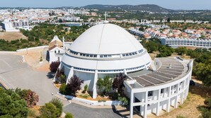 A large white dome structure with a cross on top, surrounded by greenery and a parking area. - Algarve Townhouse in Loulé by MGM Stays (Loulé)