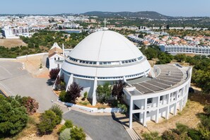 A large white dome structure with a cross on top, surrounded by greenery and a parking area. - Algarve Townhouse in Loulé by MGM Stays (Loulé)