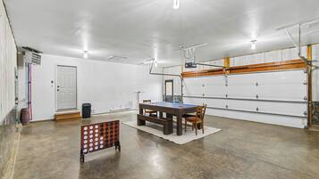 Un amplio espacio interior con mesa de ping pong, sillas y un banco de madera.