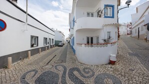 A cobblestone street with buildings on either side, a no parking sign, and a satellite dish on a building. - Lemon House – Cozy Home Near the Beach and City Center (Lagos)