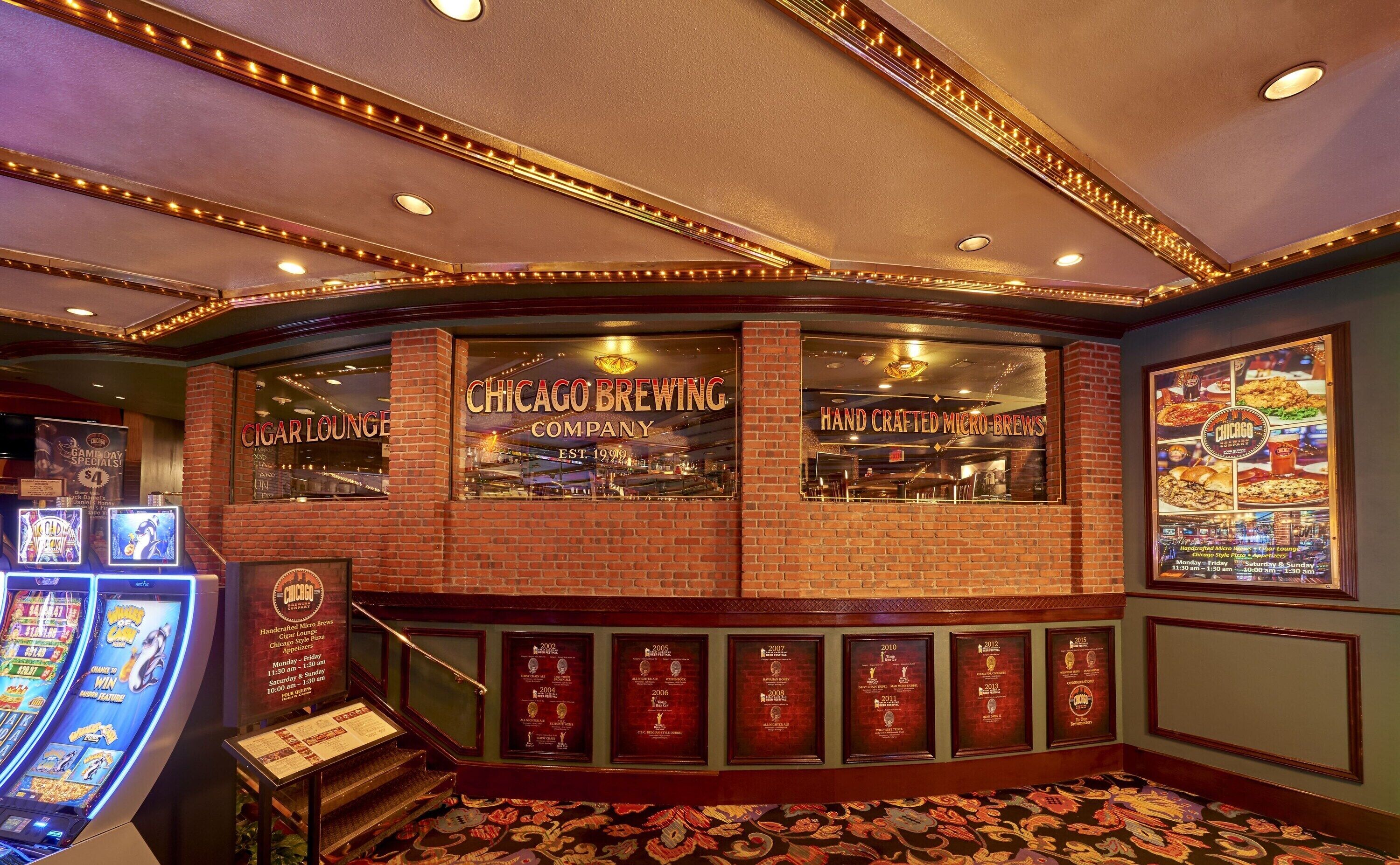 Zona de bar con paredes de ladrillo, señalización iluminada que dice 'Chicago Brewing Company' y 'Cigar Lounge'.