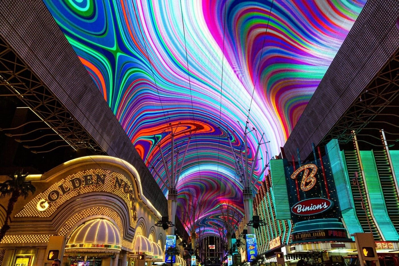 A vibrant indoor space with a large digital display, a prominent 'Golden Nugget' sign, and a 'Binion's' sign.