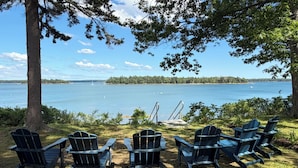 Zona relax sul lago con poltrone Adirondack e un pontile.