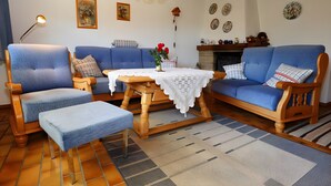 Un salon comprenant un ensemble de canapés, une table basse en bois, une lampe et une cheminée.