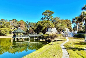 A park with a gazebo, a pond, and a pathway.