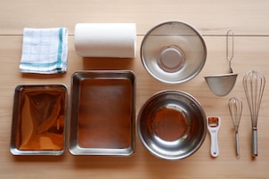 Una cocina con diversos utensilios y utensilios de cocina, incluyendo un rodillo, un colador, un batidor y moldes para hornear.