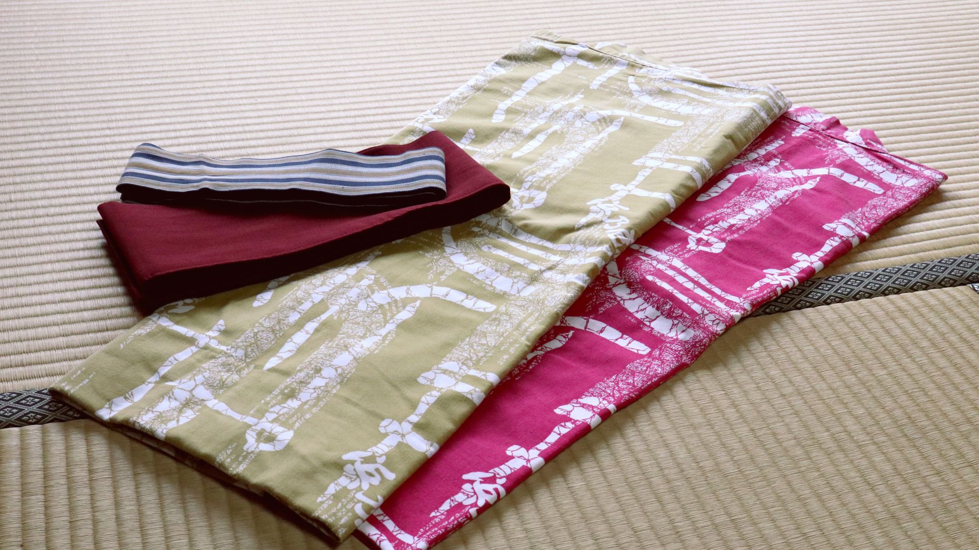 A bed with a striped pillow and folded blankets.