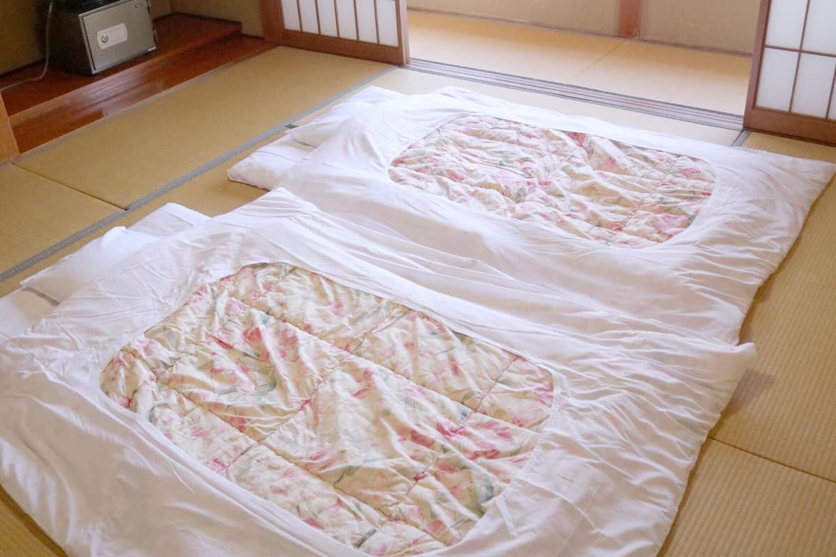 Tatami mats with a quilted blanket in a traditional Japanese room.