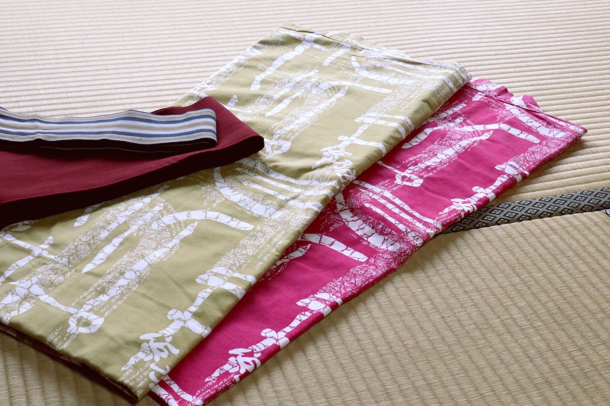 A bed with a striped pillow and folded blankets.