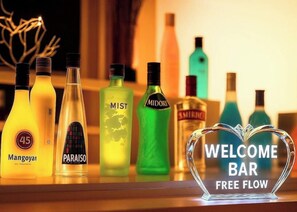 A selection of liquor bottles on a shelf with a 'WELCOME BAR FREE FLOW' sign. - Super Hotel JR Nara Station Sanjo Street (Hikone)