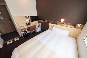 A hotel room with a bed, a desk, a chair, a television, and a small kitchenette. - Super Hotel JR Nara Station Sanjo Street (Hikone)