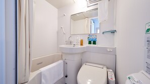 A small, modern bathroom with a white sink, a toilet, and a mirror above the sink. There are toiletries on the sink and a towel hanging on the wall. - Super Hotel JR Nara Station Sanjo Street (Hikone)