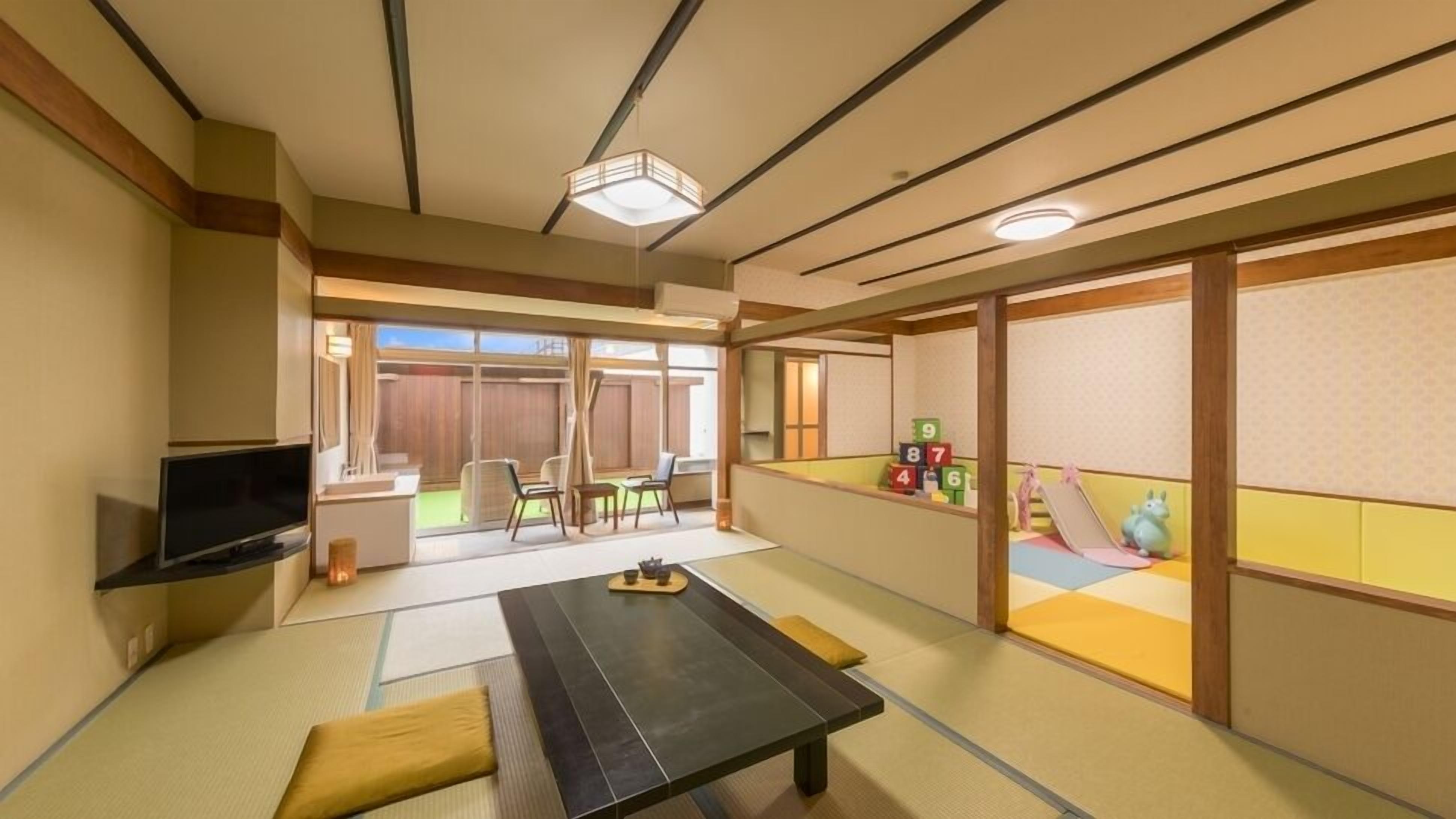 A traditional Japanese-style room with tatami flooring, a low table, a television, and a sliding door leading to an outdoor area with a playset.