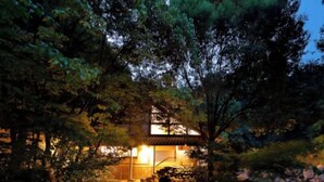 A traditional Japanese-style building with a stone pathway leading to a small pond, surrounded by trees. - Ureshino Onsen Taishouya (Ureshino)