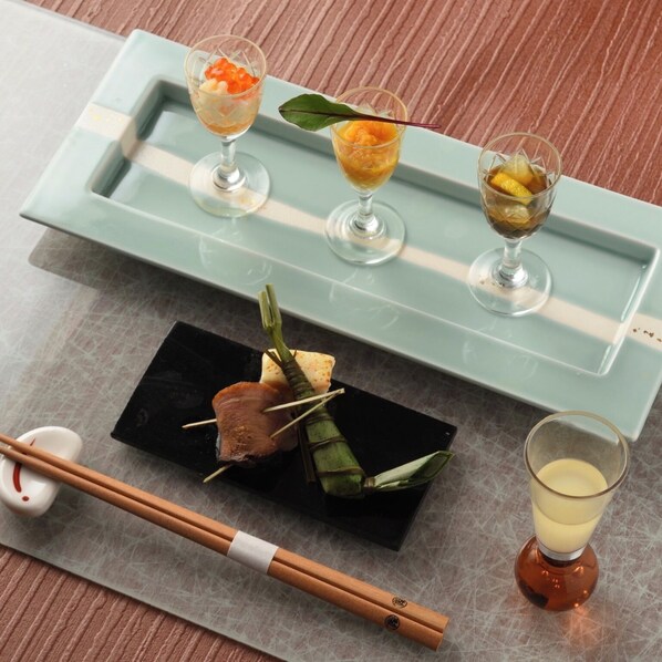A tray with three glasses of food, a plate with a wrapped item, chopsticks, and a glass of drink. - Hotel Zuiyo (Atami)