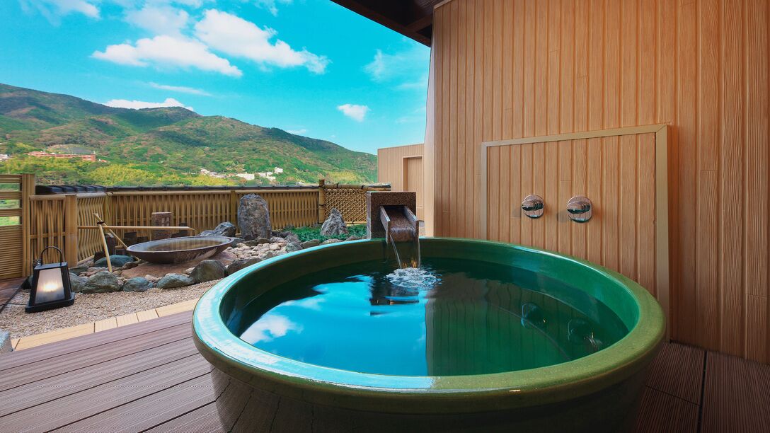 A hot tub on a wooden deck with a view of mountains.