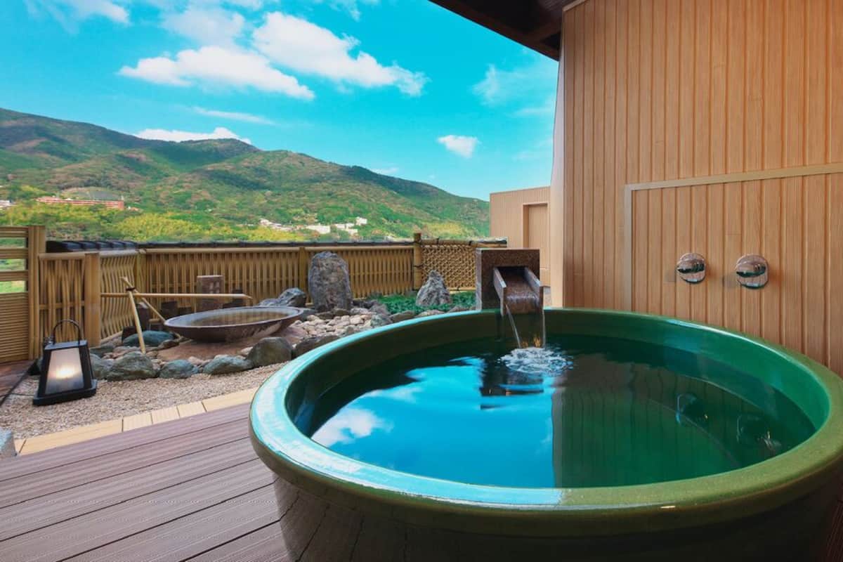 A hot tub on a wooden deck with a view of mountains.