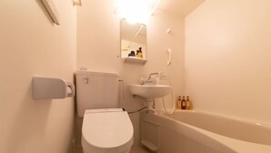 Une salle de bain avec des toilettes, un lavabo et une baignoire.