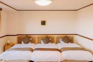 Una habitación de hotel con una cama grande, una mesita de noche y un pequeño cuadro en la pared.