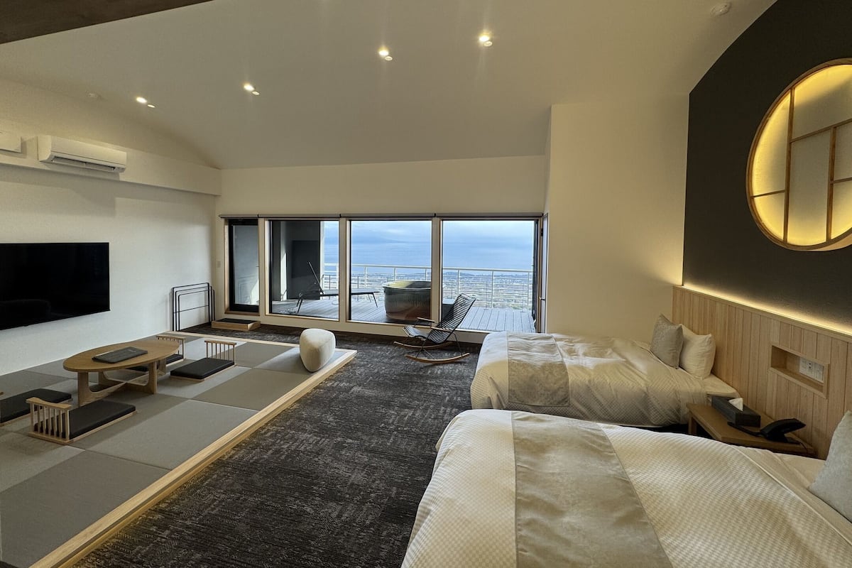 Une chambre d’hôtel moderne équipée d’un grand lit, d’un canapé, d’une table à manger et d’un téléviseur.