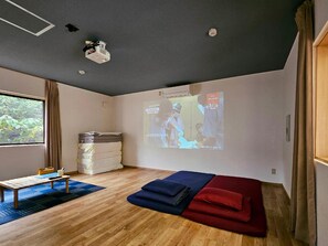 A modern room with a projector on the ceiling, a bed with pillows, a small table, and a window with curtains. - Sloth Glamping <tsushima> (Tsushima)