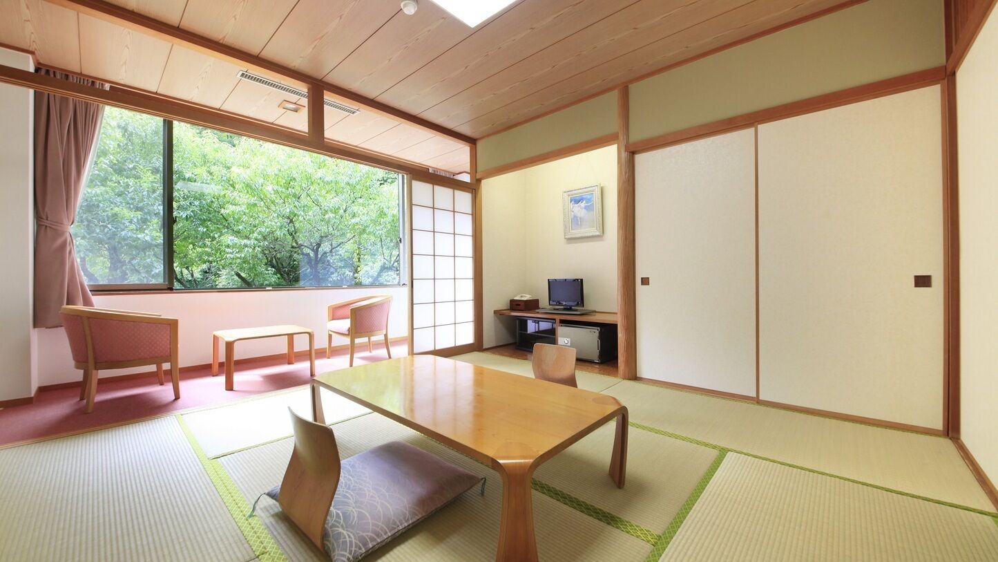 A traditional Japanese room with tatami flooring, a low table, and sliding doors.