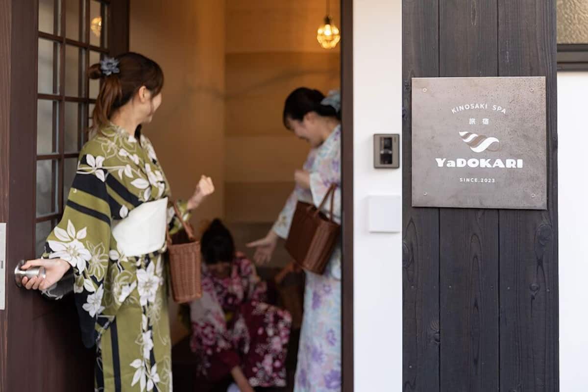 A wooden door with a plaque reading 'Kinosaki Spa YaDokari since 2023.'