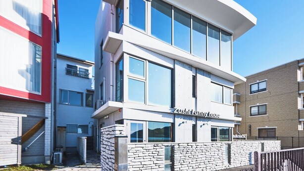 Un edificio moderno de varios pisos con un restaurante llamado 'Zushi House' en la planta baja.
