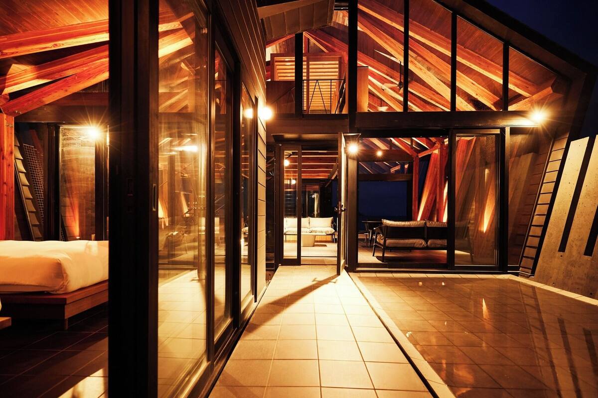 A modern, well-lit interior with a spacious layout, including a bedroom and a seating area.
