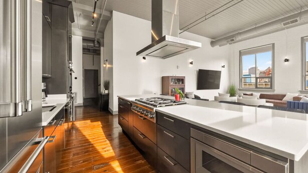 Una cocina moderna con electrodomésticos de acero inoxidable, una isla grande y vistas de la ciudad.