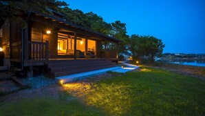 A modern house with a wooden deck, outdoor seating, and a pathway leading to the entrance. - Mizube No Hanare Calme (Kyotango)