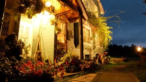 A house with a porch, potted plants, and a wooden pathway leading to the entrance. - Tabi Yado Rantan (Shinano)