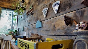 A rustic interior with wooden walls, a number 7 sign, and various items including a yellow box labeled 'PEPSI'. - Tabi Yado Rantan (Shinano)