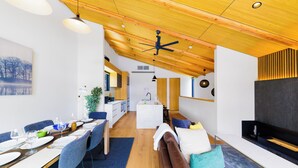 A modern interior with a dining area, a living room, and a kitchen. - Credence Chalets (Hakuba)