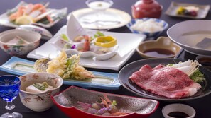 Diverses platillos i utensilis sobre una taula, com ara sushi, tempura i sashimi.