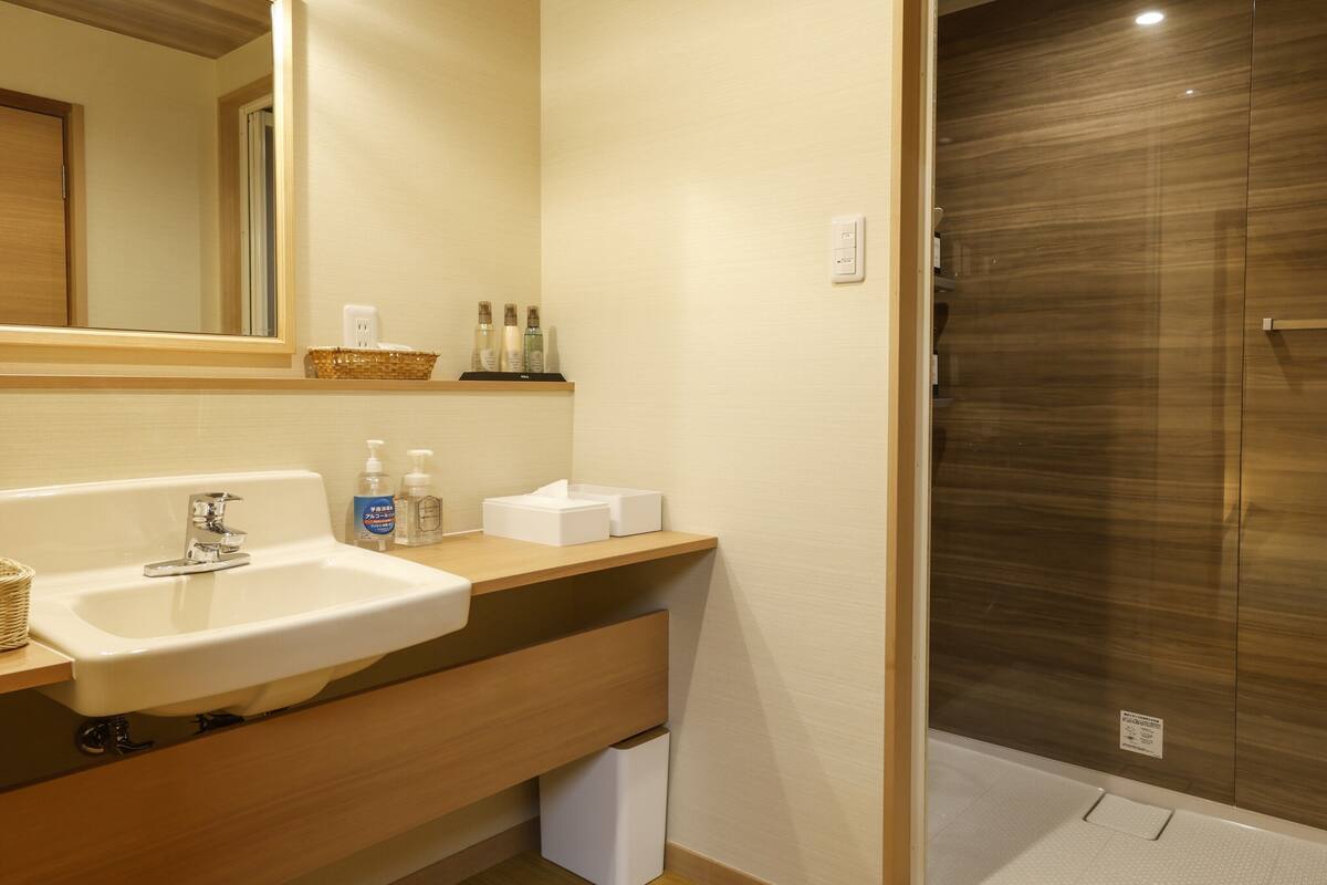 A bathroom with a sink, mirror, and toiletries.