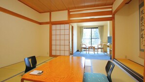 Ein traditioneller japanischer Raum mit Tatami-Böden, einem Holztisch und einer Schiebetür.