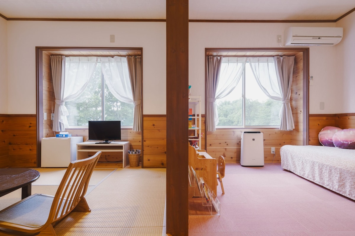 A room with a bed, a desk with a computer, a chair, and a television.