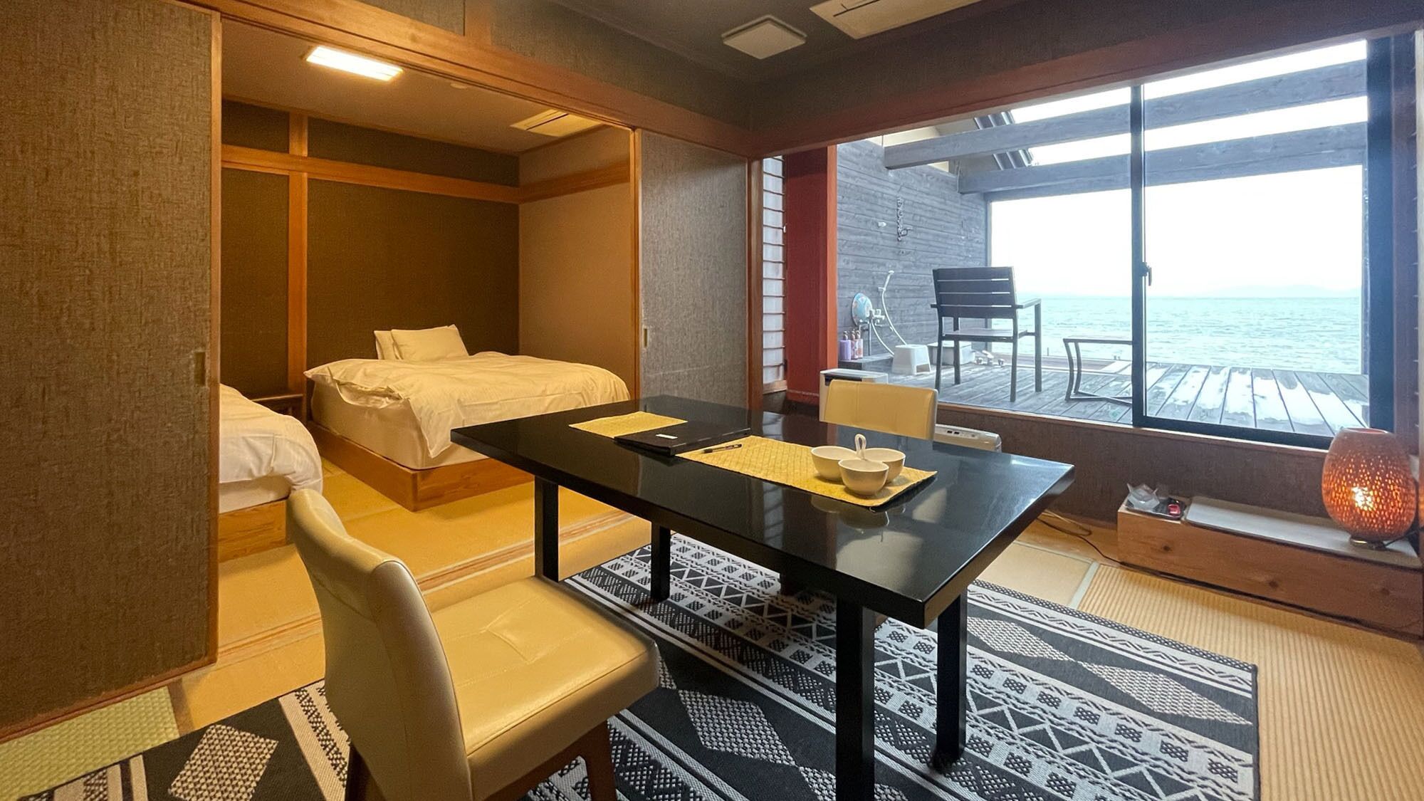 Habitación de hotel con cama, escritorio, silla, mesa y vista al mar.